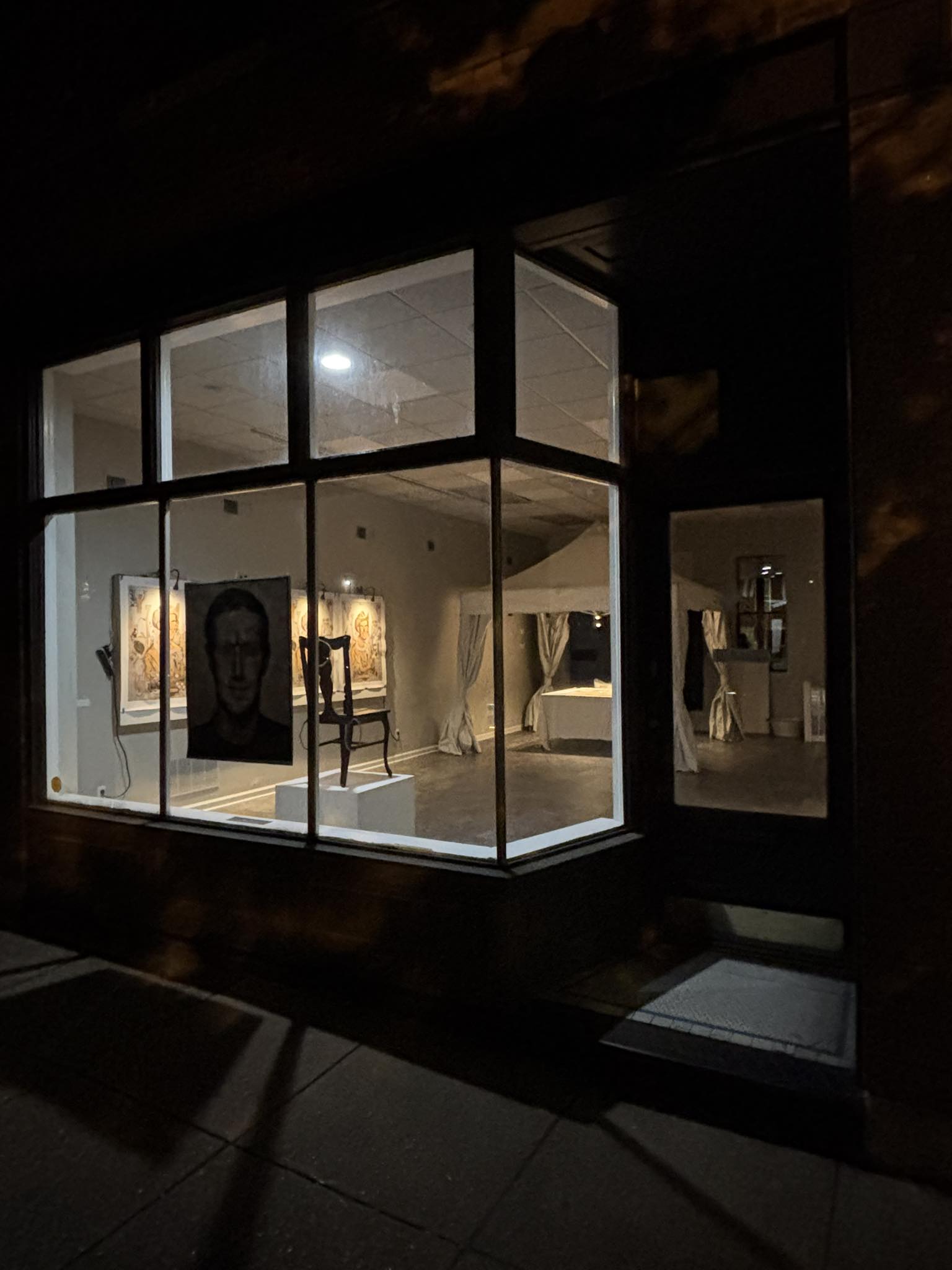 Cherokee Storefront at night with lights glowing showing art of David inside
